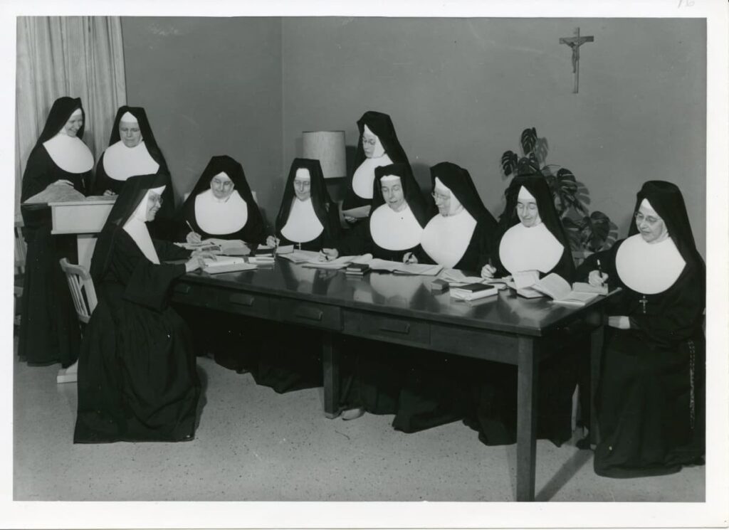 Historical photograph of sisters in habits at a table.