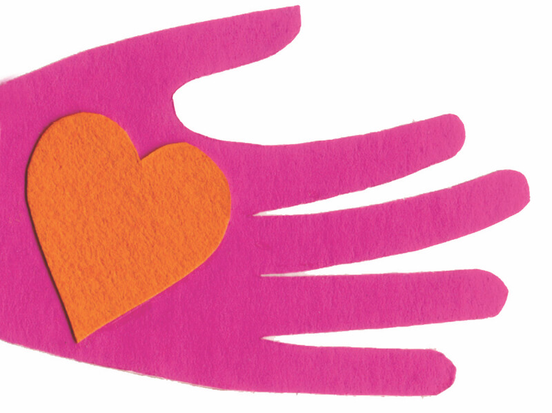 A hand cut out of pink felt holding an orange cut-out felt heart.