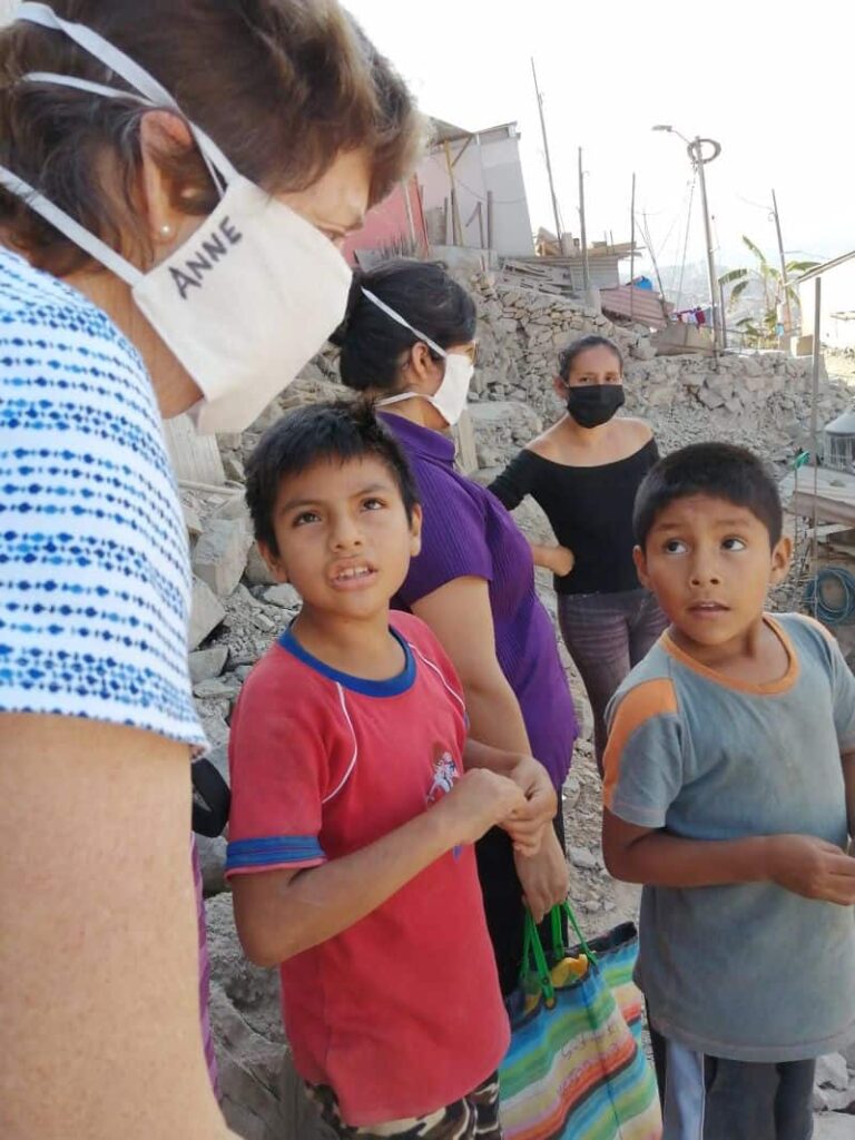 Sisters Anne and Yolanda speak with their neighbors in Lima, Peru