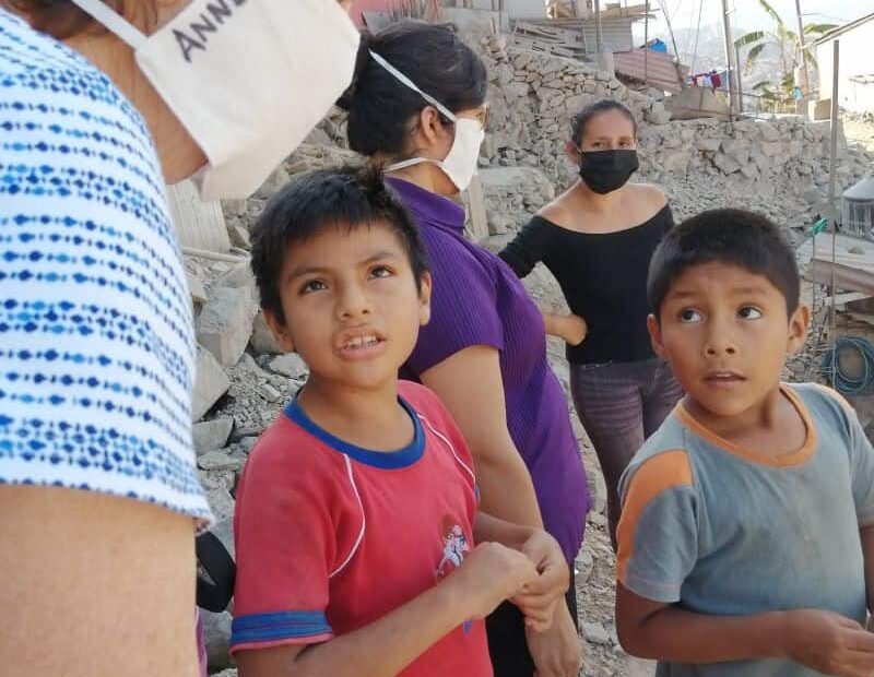 Sisters Anne and Yolanda speak with their neighbors in Lima, Peru