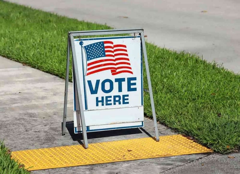 Sign reading "Vote here"