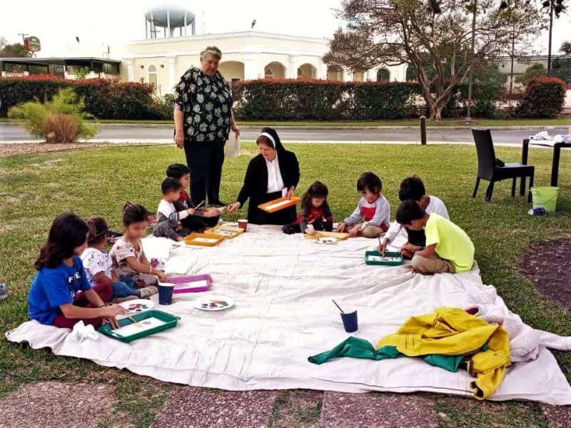 Sister Donna Gibbs working with a group of children doing art