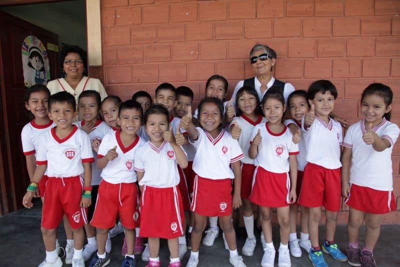 A group of young Fe y Alegría students give a thumbs up to the camera