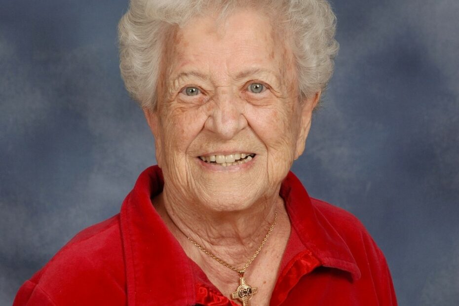 Headshot of Sister Alice Roberta Benzing in a red shirt with a blue background