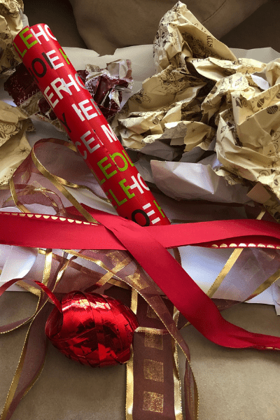 A pile of crumpled wrapping paper and discarded red and gold ribbons