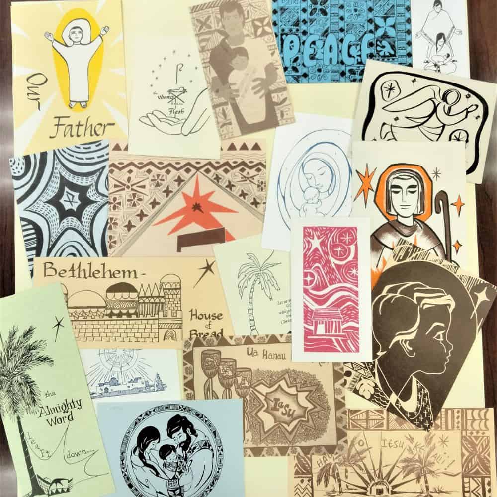 A collection of 20 colorful hand-drawn Christmas cards is scattered across a desk.