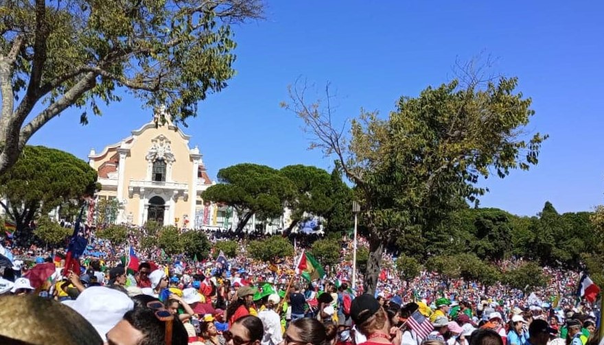 World Youth Day 2023 Pilgrims standing in a massive crowd.