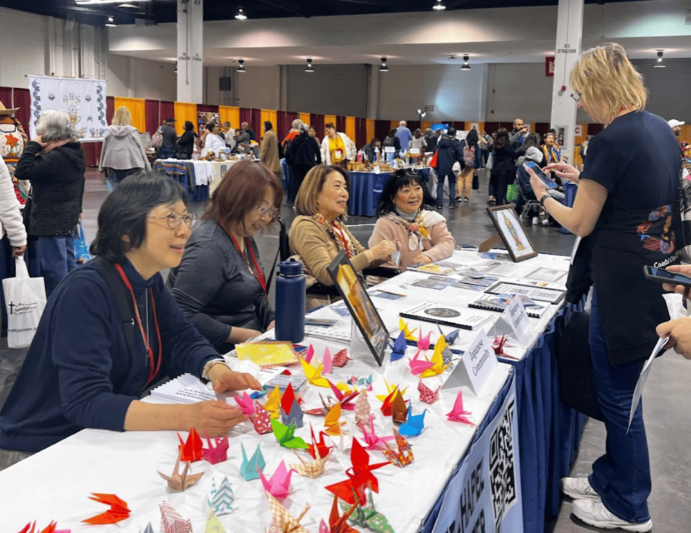 Four women representing the Japanese Catholic community from St. Francis Xavier Church in Los Angeles running a booth at the Religious Education Congress