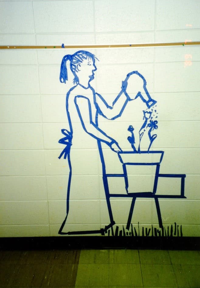 Blue painters tape on a wall in the shape of a woman watering flowers