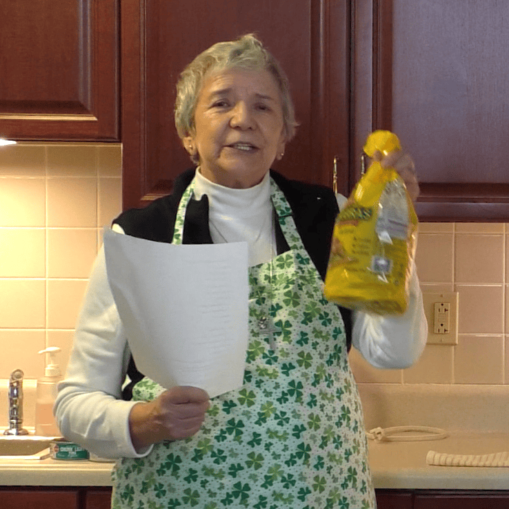 Sister Rosario holding tostada shells and a printed recipe