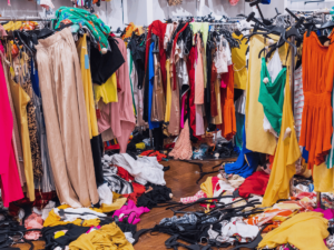 Store clothing racks in complete disarray with clothes even fallen to the floor