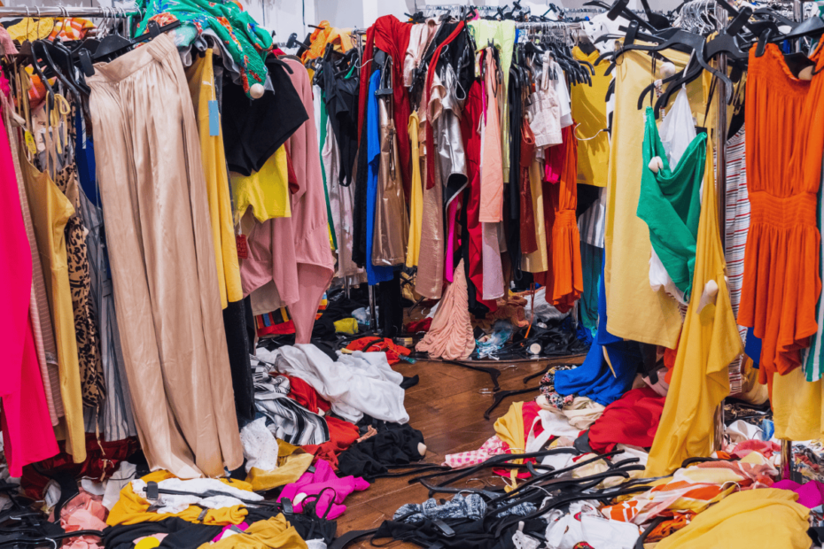 Store clothing racks in complete disarray with clothes even fallen to the floor