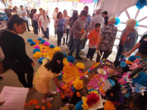 Putting flowers on the Dia de los Muertos alter at the Mexicali shelter