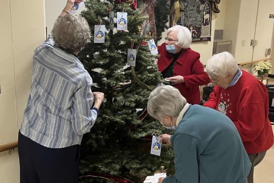 Four sisters hanging prayer ornaments on a tree