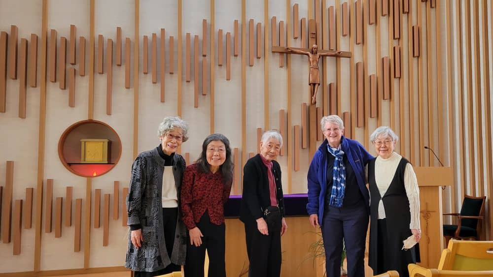 Five sisters pose together in front of an altar and crucifix