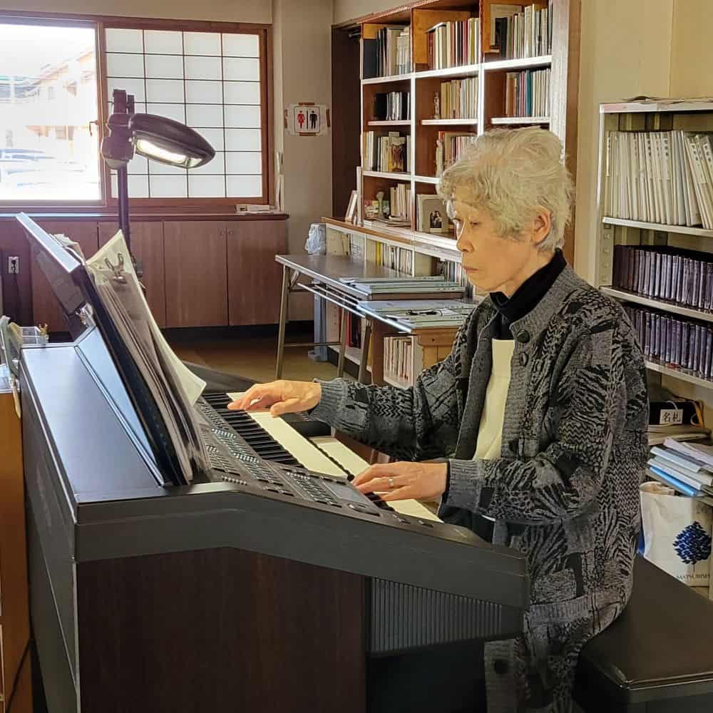 A sister concentrates on playing the organ in a brightly lit church