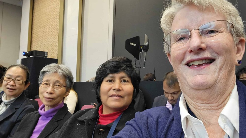 Patty Johnson takes a selfie with three sisters as they observe talks in Busan