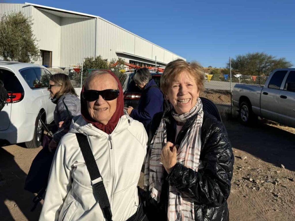 Two women pose for a photo outside the Kino Border Initiative