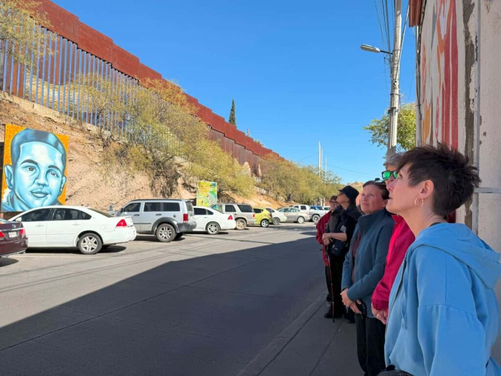 A group gaze at the border wall between Mexico and the United States