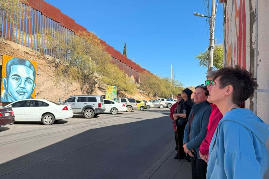 A group gaze at the border wall between Mexico and the United States