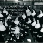 Fourteen sisters in habits creating little nun dolls