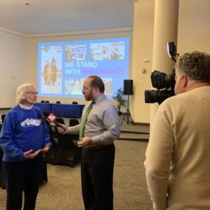 A sister being interviewed by a news station about standing up for immigrants