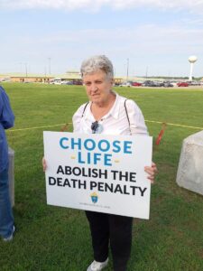 Sister Nancy holding a sign that says "Choose life abolish the death penalty"