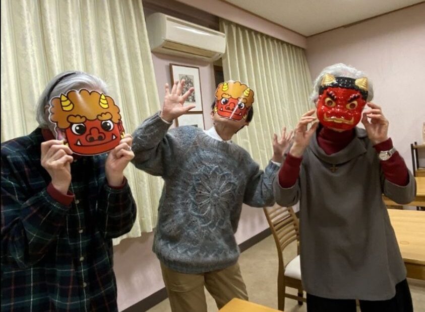 Three sisters wearing ogre masks for the Lunar New Year